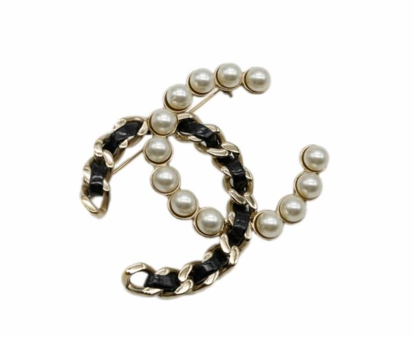 Broche con perlas y cuerda negra